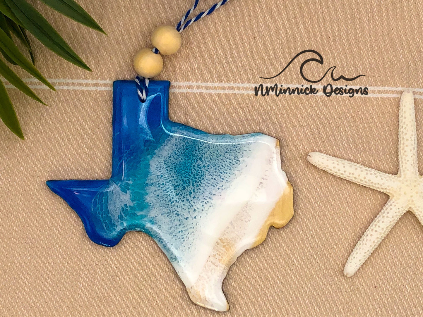 Texas shaped laser cut wood ornament. 1/8 inch thick and approximately 4-4.5 inches wide.  Covered in epoxy resin with blue, teal, and white to make it look like waves on a beach.