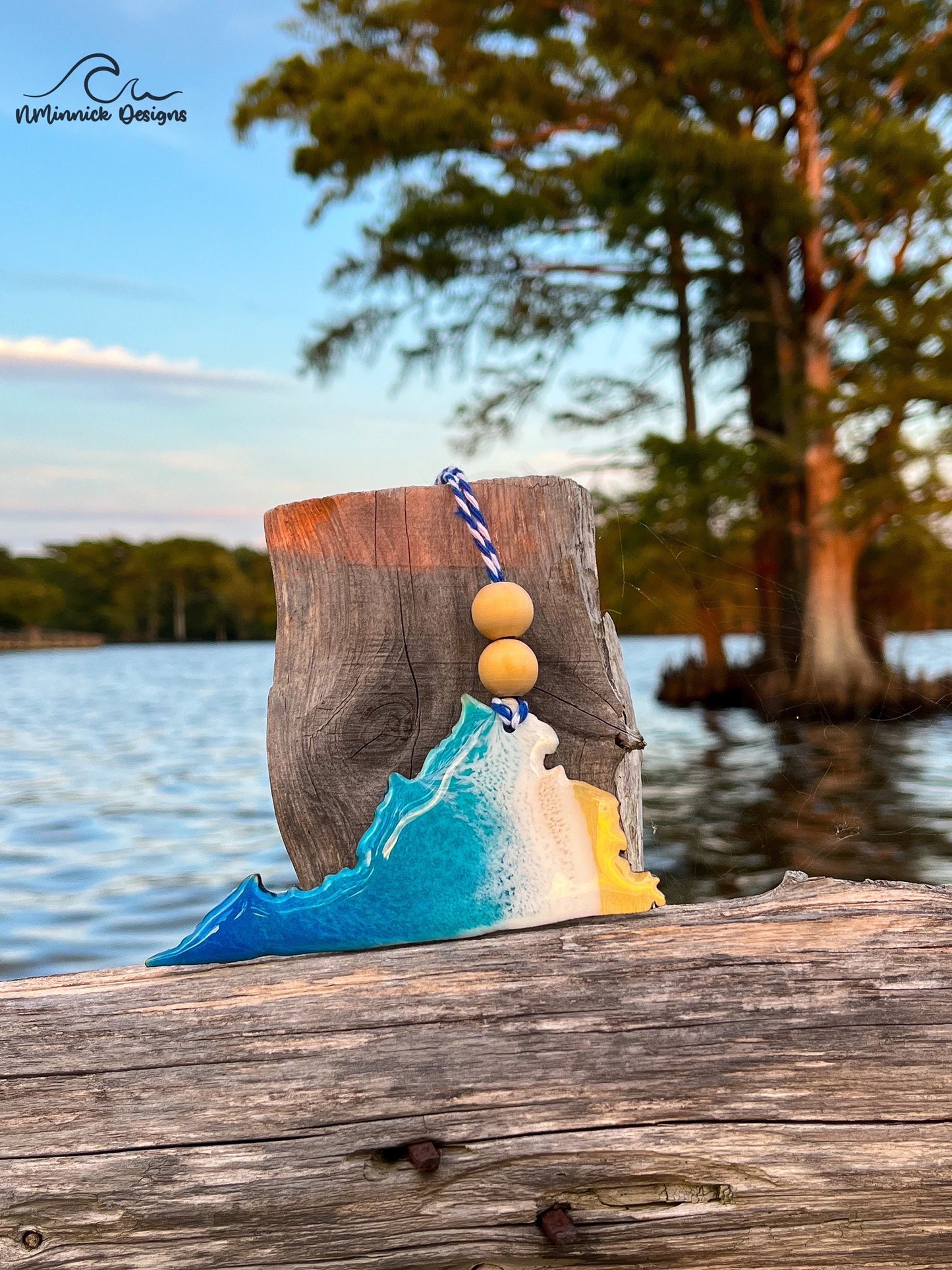 Virginia-shaped wooden Christmas ornament covered in blue and teal colored ocean resin art resembling the waves along Virginia's Atlantic Coast. Finished with blue and white baker's twine and two wooden beads.