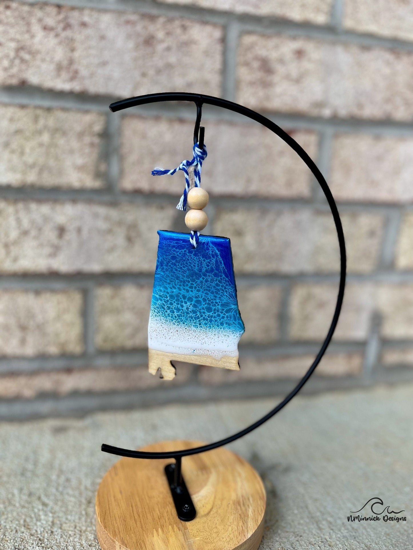 Alabama ornament with ocean resin art and hanging from an ornament stand.