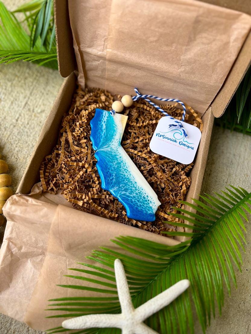 California ornament featuring ocean resin art and finished with two wooden beads and blue and white twine.