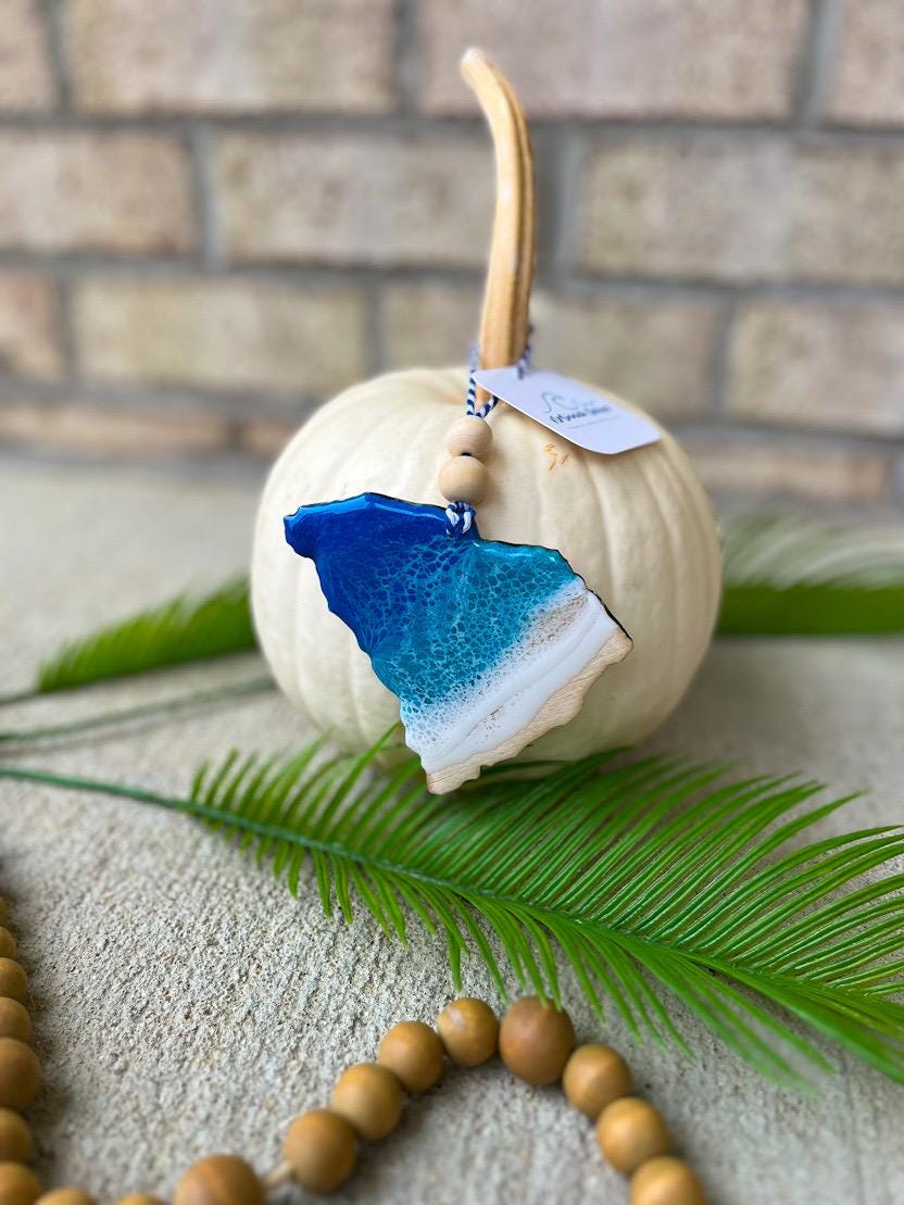 Handmade South Carolina ocean resin ornament resting on a white pumpkin, Charleston coastal decor inspired by ocean waves