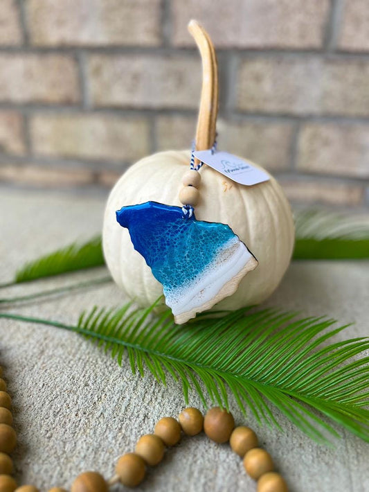 Handmade South Carolina ocean resin ornament resting on a white pumpkin, Charleston coastal decor inspired by ocean waves