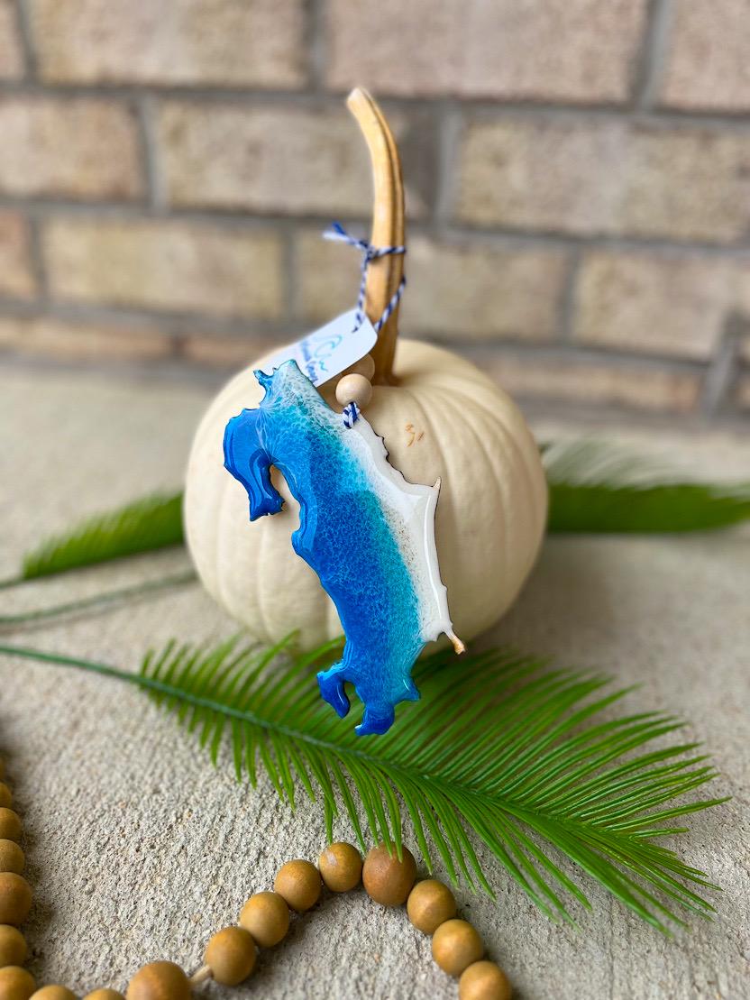 Handmade Costa Rica ocean resin ornament resting on a white pumpkin, tropical beach-inspired design with ocean wave details