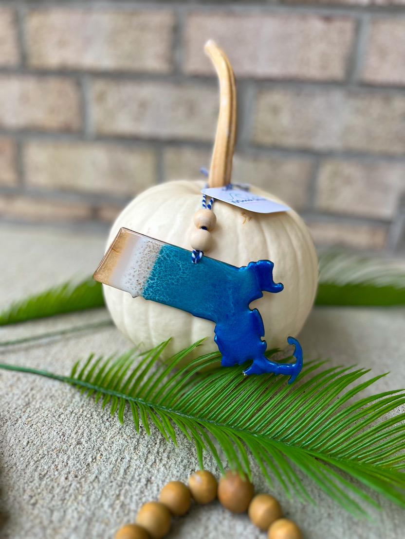 Handmade Massachusetts ocean resin ornament resting on a white pumpkin, coastal design inspired by Cape Cod and Nantucket beaches with ocean wave details