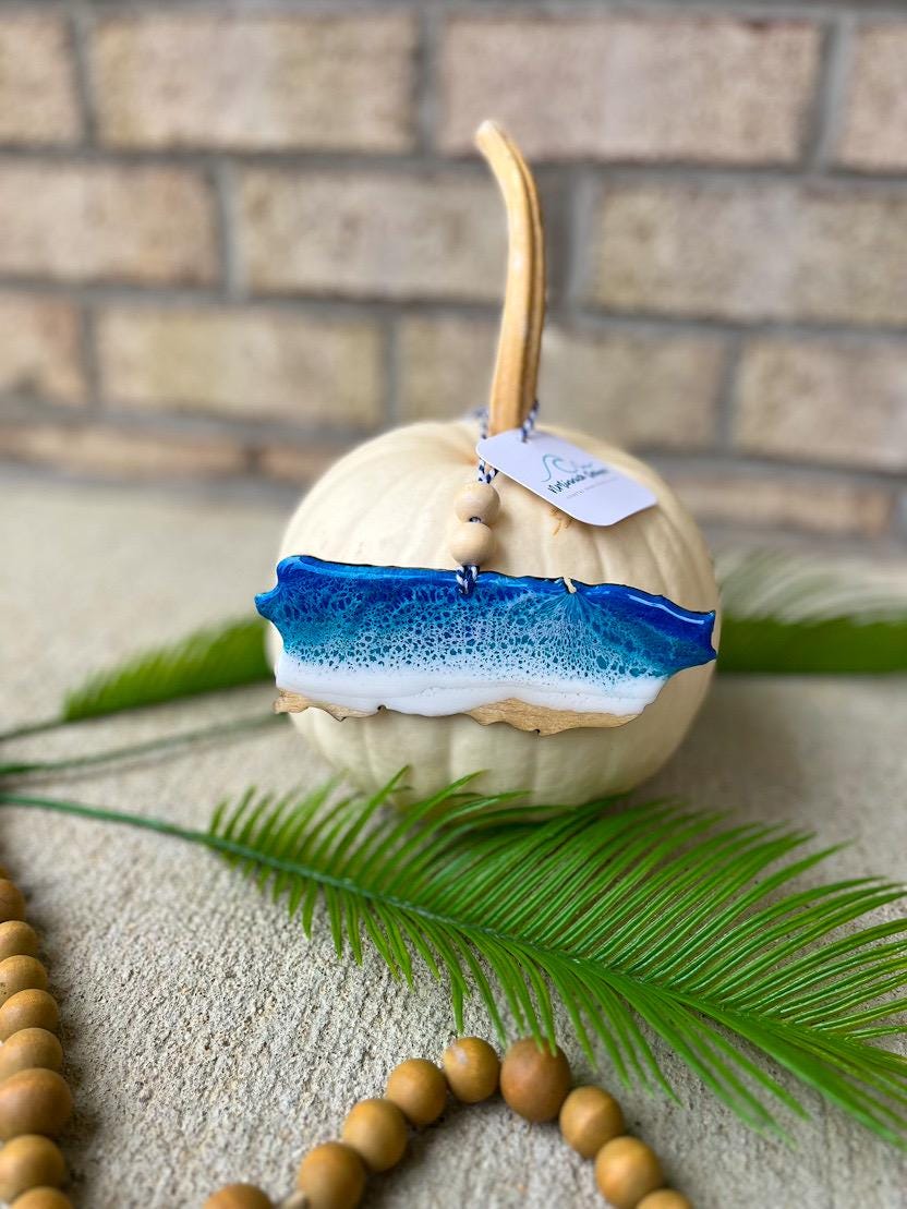 Handmade Puerto Rico beach-themed ocean resin ornament resting on a white pumpkin, coastal design featuring ocean wave details