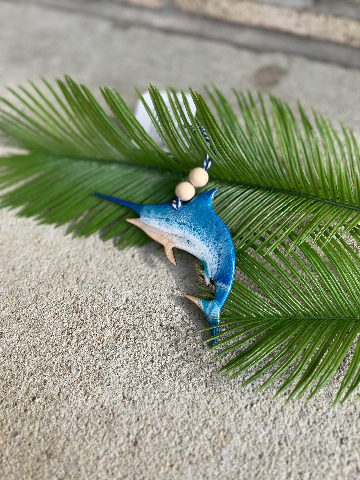 Marlin Ocean Ornament laying against palm leaves