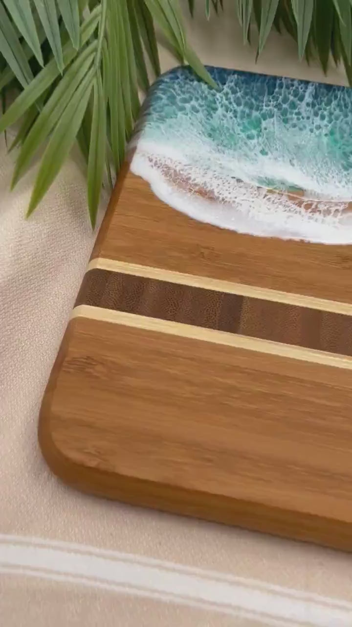 Bamboo Serving Tray laser engraved with a seashell and Happy Birthday on the bottom and covered in blue and teal ocean resin art that resembles the waves of the ocean.