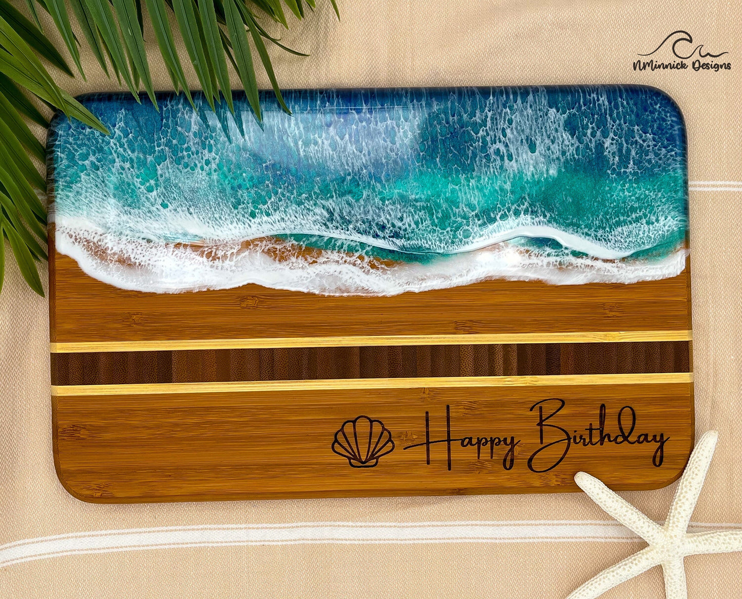 Bamboo Serving Tray laser engraved with a seashell and Happy Birthday on the bottom and covered in blue and teal ocean resin art that resembles the waves of the ocean.