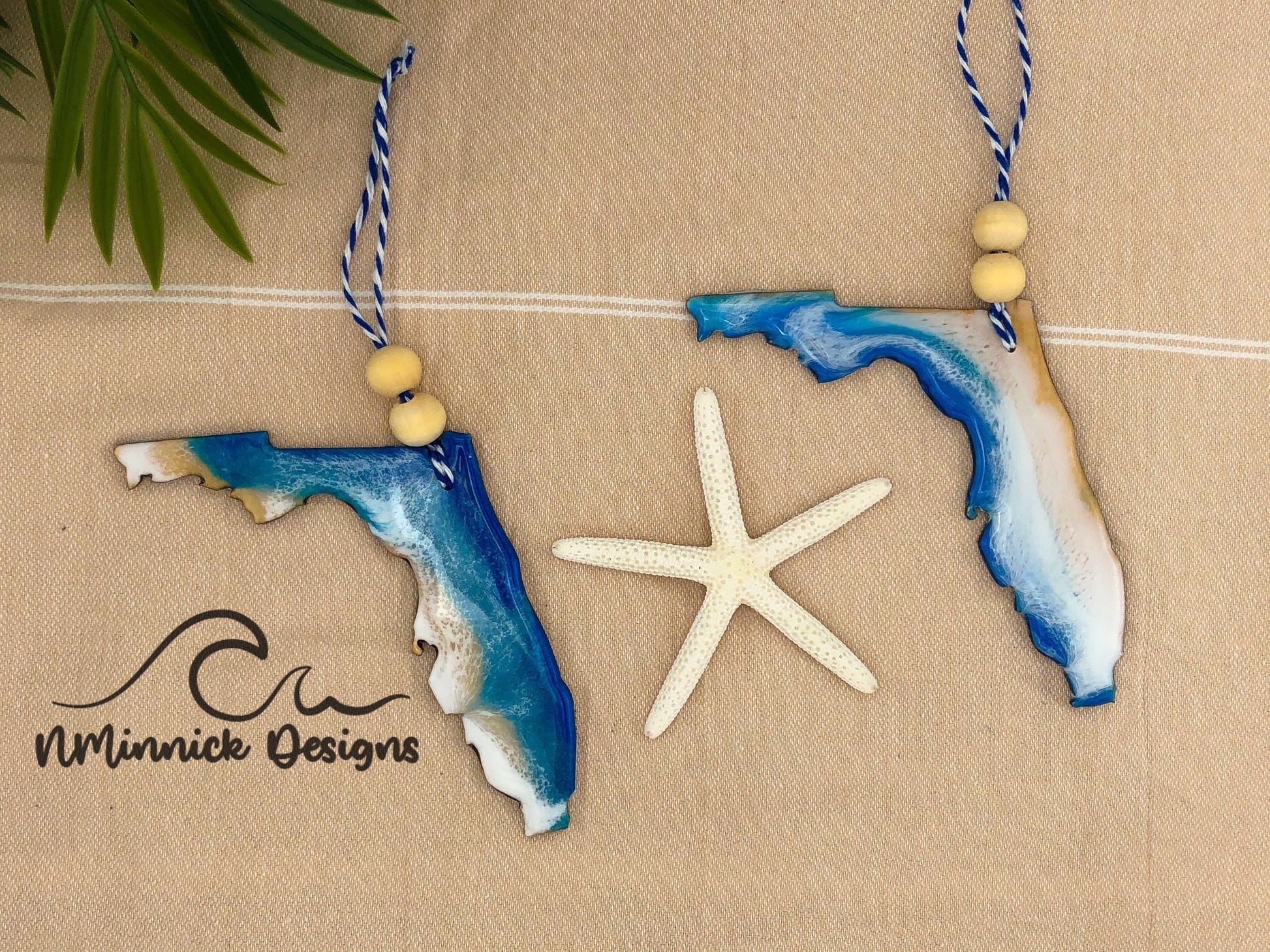 Laser cut wood and resin ornaments in the shape of florida. Two variations with ocean waves on either the atlantic or gulf side of the state. Finished with bakers twine and two wooden beads.