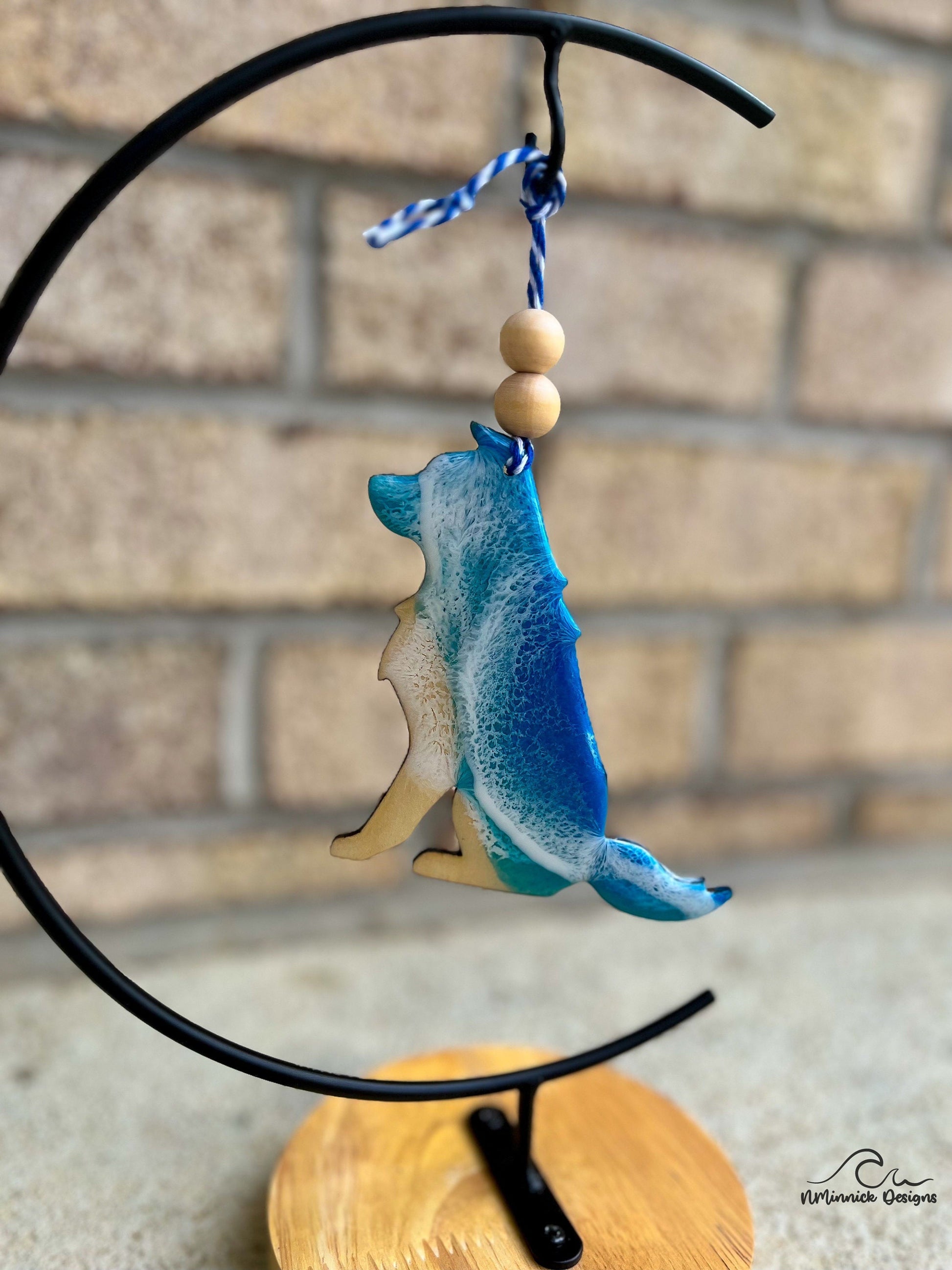 Dog shaped ornament with ocean resin art hanging from an ornament stand.