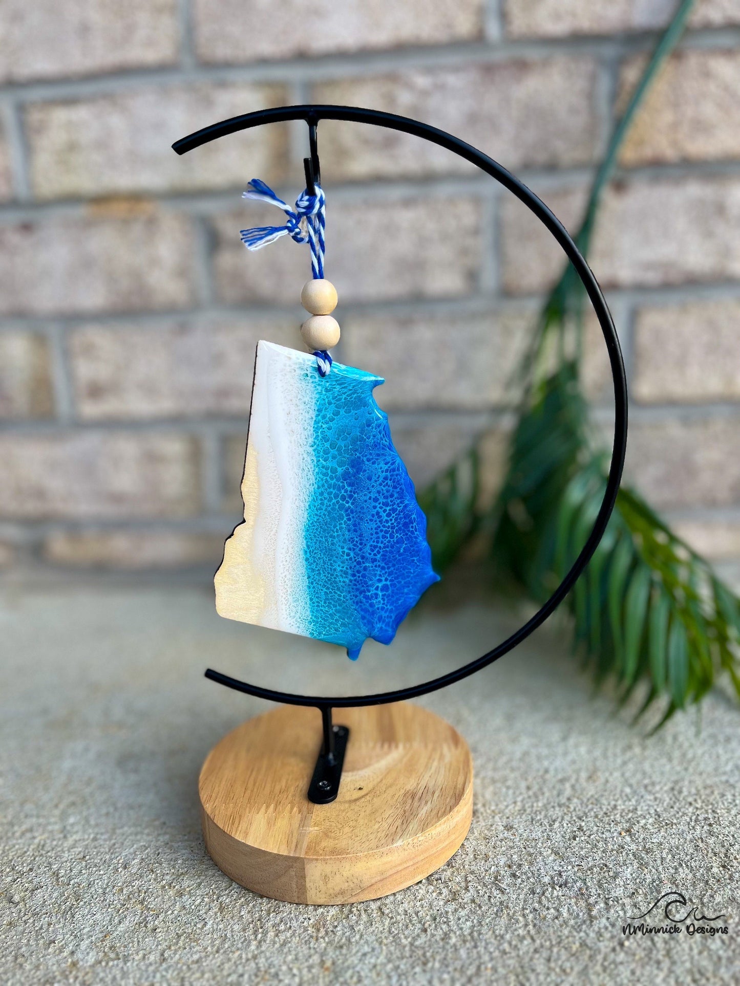 Handmade Georgia shaped wooden ornament featuring ocean resin waves, finished with blue and white twine and two natural wooden beads