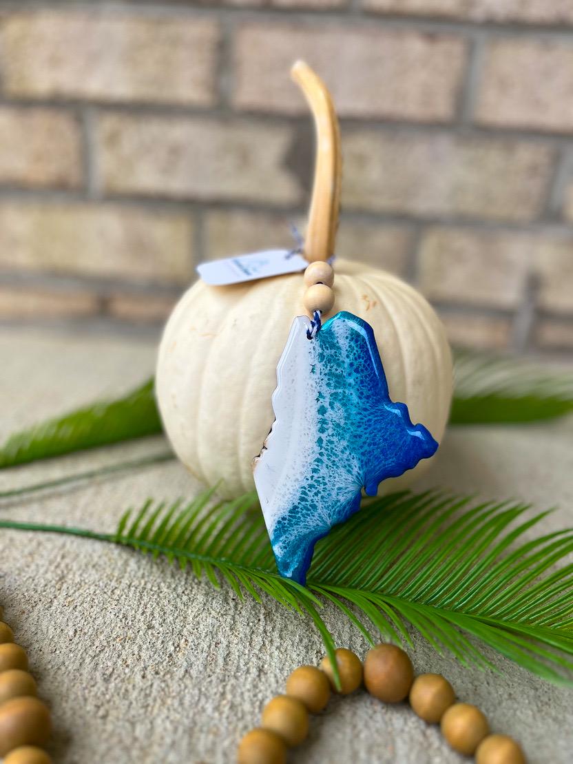 Handmade Maine ocean resin ornament resting on a white pumpkin, coastal design inspired by Acadia National Park and Maine’s rocky beaches