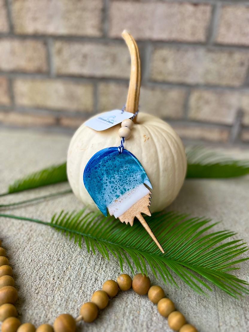 Coastal horseshoe crab ornament with ocean resin waves displayed on a white pumpkin, handmade beach-inspired decoration