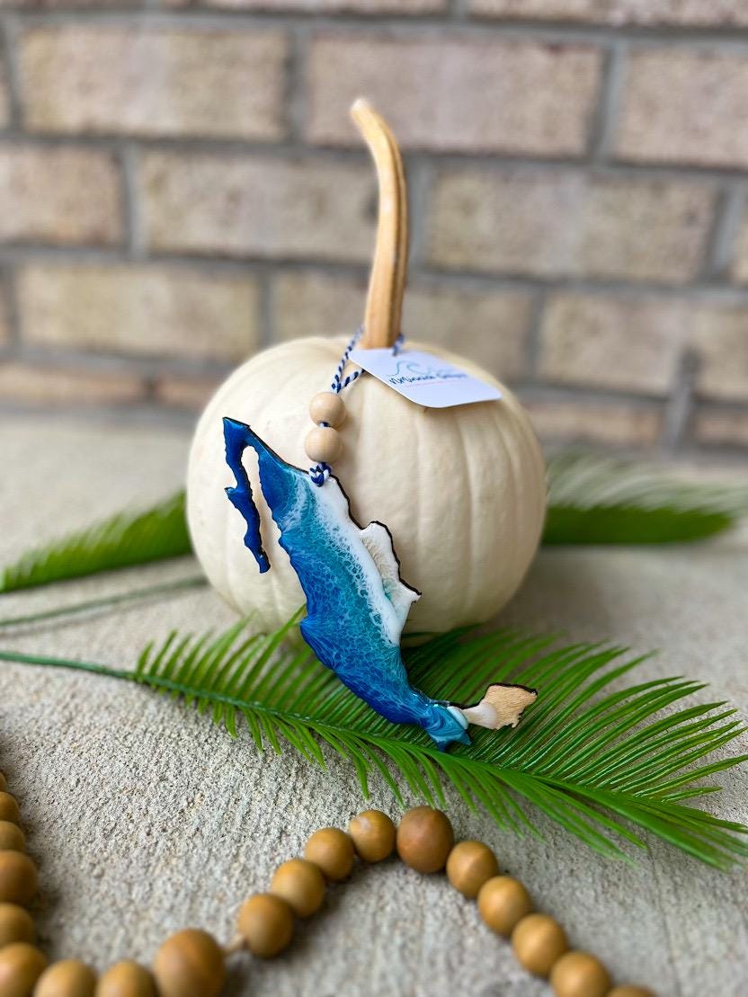 Handmade Mexico ocean resin ornament resting on a white pumpkin, tropical beach-inspired design with ocean wave details