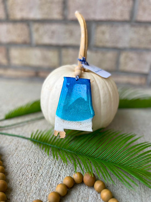 Handmade Alabama ocean resin ornament resting on a white pumpkin, coastal design inspired by Alabama beaches and ocean waves