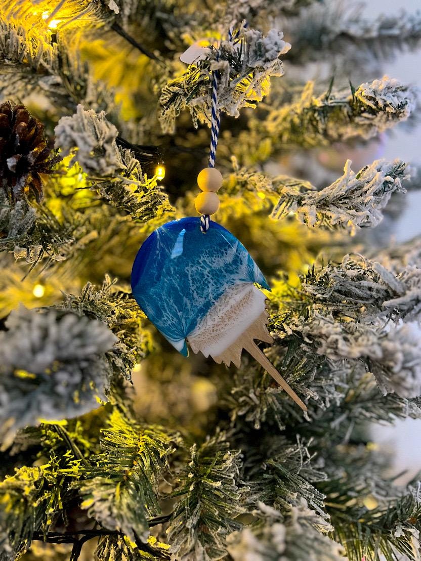 Handmade Horseshoe Crab shaped wooden ornament featuring ocean resin waves, finished with blue and white twine and two natural wooden beads