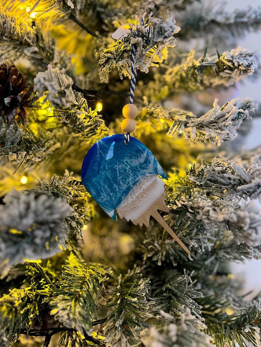 Handmade Horseshoe Crab shaped wooden ornament featuring ocean resin waves, finished with blue and white twine and two natural wooden beads