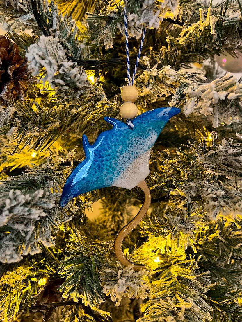 Handmade Manta Ray shaped wooden ornament featuring ocean resin waves, finished with blue and white twine and two natural wooden beads