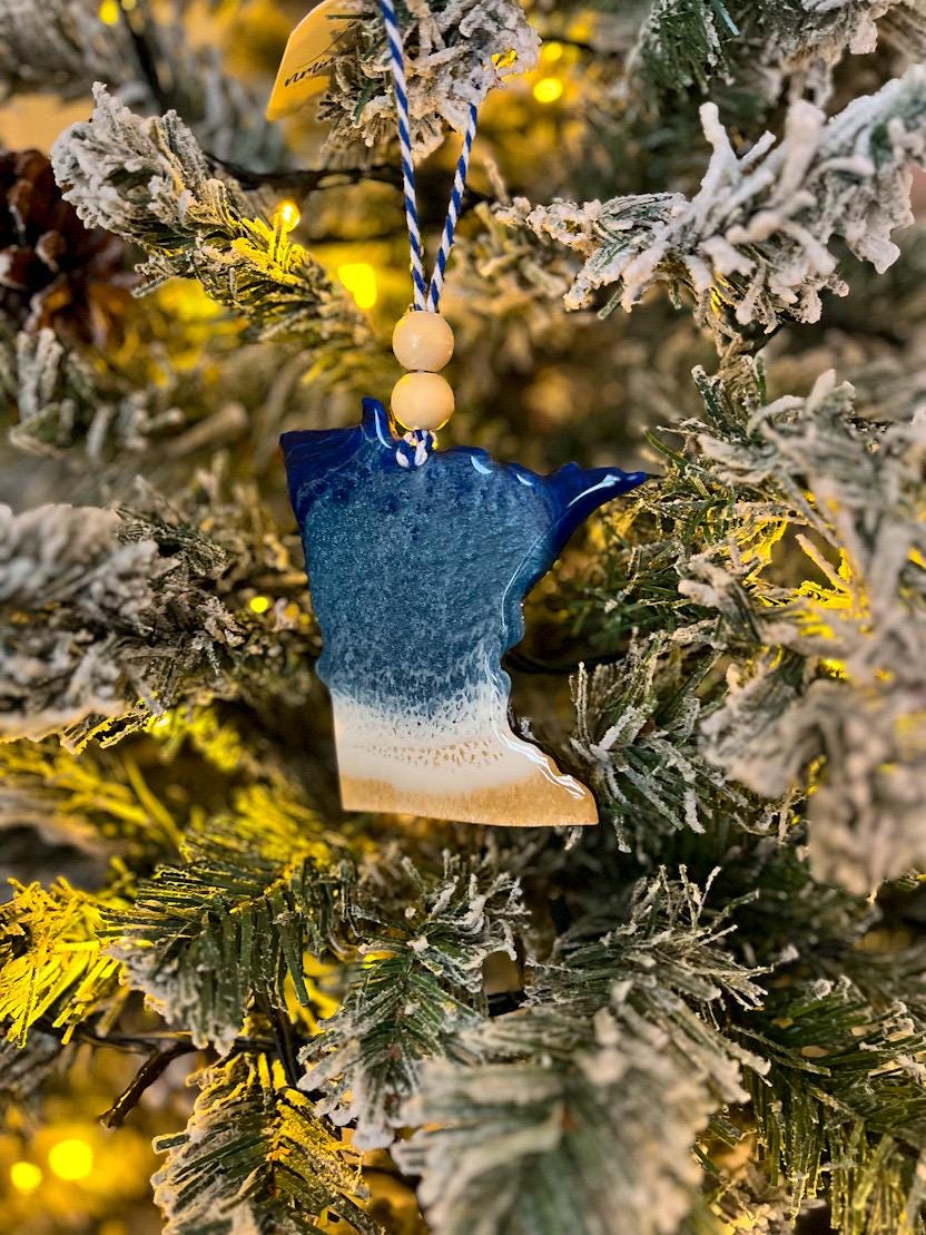Handmade Minnesota shaped wooden ornament featuring resin waves, finished with blue and white twine and two natural wooden beads