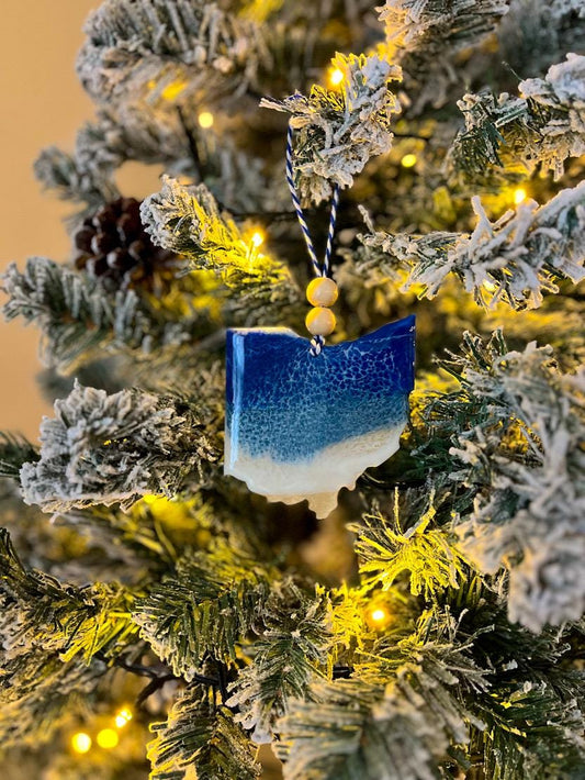 Handmade Ohio shaped wooden ornament featuring resin waves, finished with blue and white twine and two natural wooden beads
