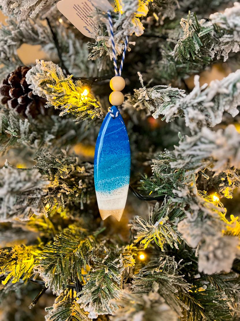 Handmade surfboard shaped wooden ornament featuring ocean resin waves, finished with blue and white twine and two natural wooden beads