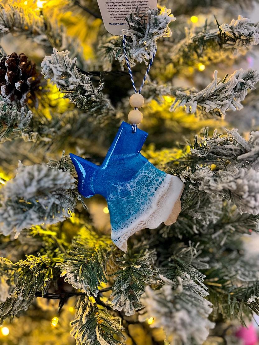 Handmade Texas shaped wooden ornament featuring ocean resin waves, finished with blue and white twine and two natural wooden beads