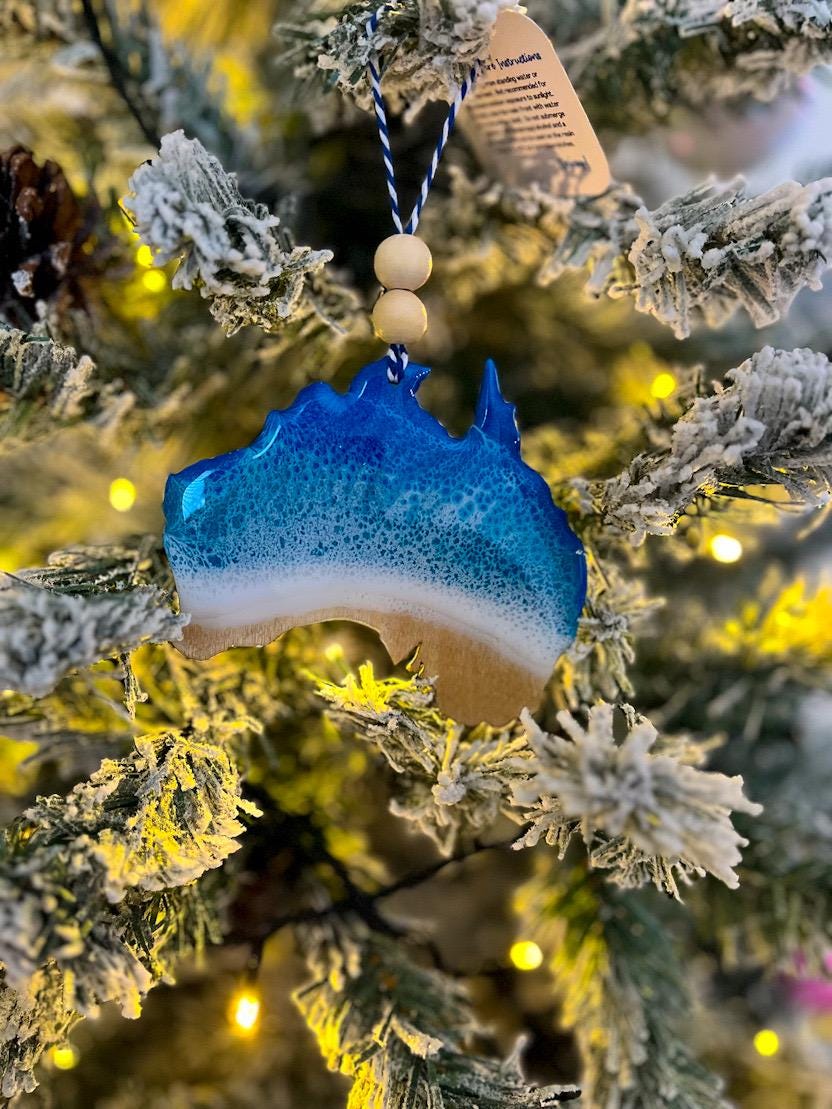 Handmade Australia shaped wooden ornament featuring ocean resin waves, finished with blue and white twine and two natural wooden beads