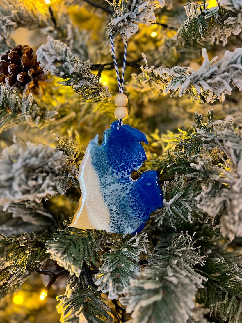 Handmade Michigan shaped wooden ornament featuring resin waves, finished with blue and white twine and two natural wooden beads