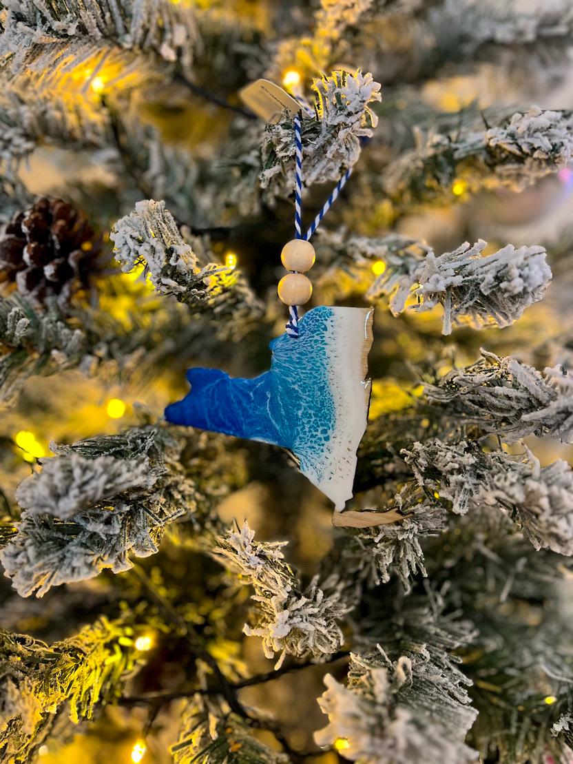 Handmade New York shaped wooden ornament featuring ocean resin waves, finished with blue and white twine and two natural wooden beads