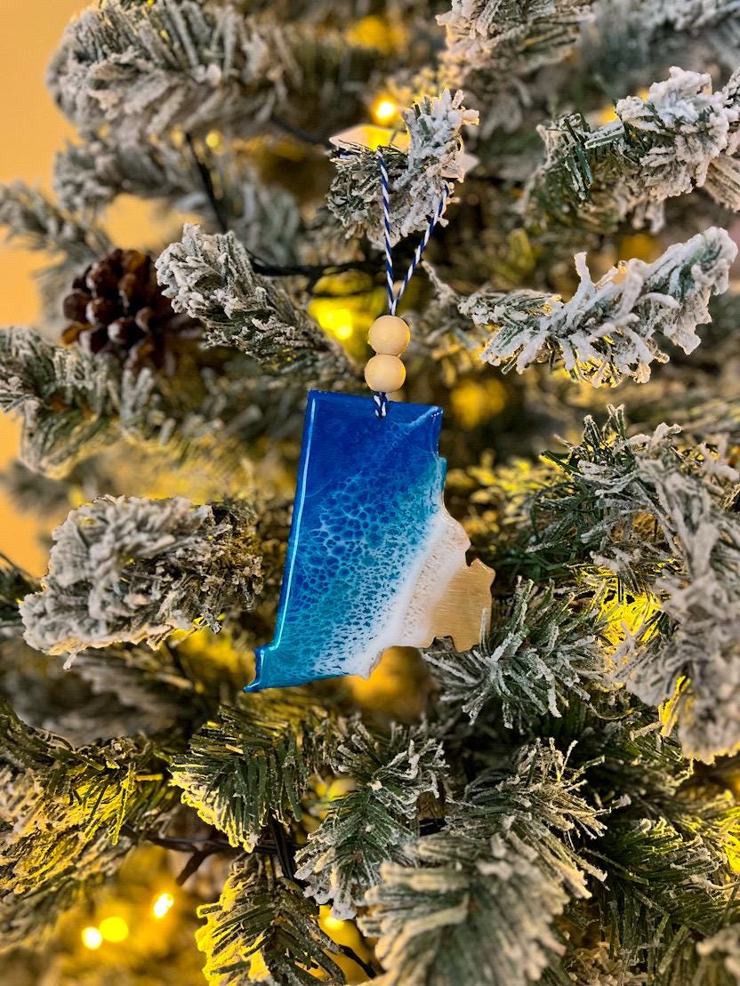 Handmade Rhode Island shaped wooden ornament featuring ocean resin waves, finished with blue and white twine and two natural wooden beads