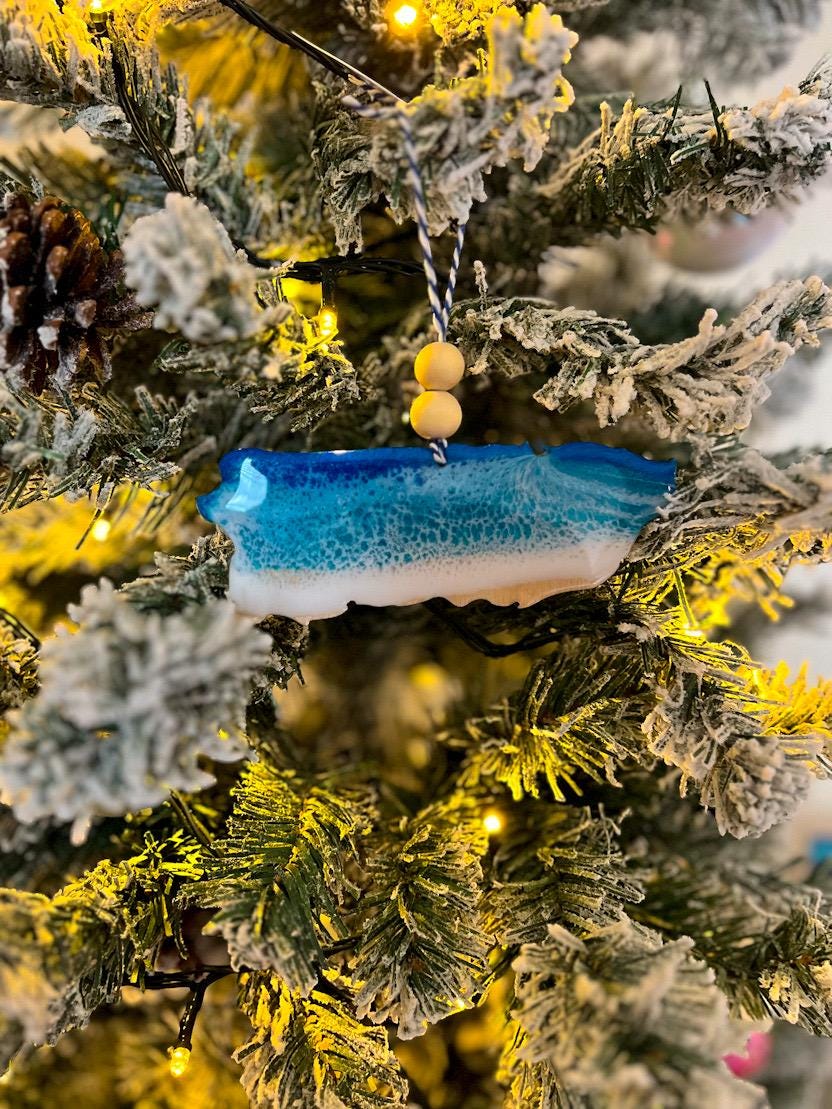 Handmade Puerto Rico shaped wooden ornament featuring ocean resin waves, finished with blue and white twine and two natural wooden beads