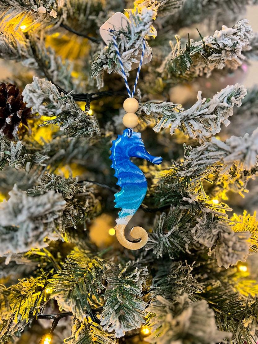 Handmade Seahorse shaped wooden ornament featuring ocean resin waves, finished with blue and white twine and two natural wooden beads