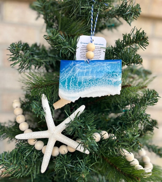 Connecticut ornament with ocean resin art and finished with two wooden beads and blue and white twine. Hanging from a christmas tree with a wooden garland and a starfish.