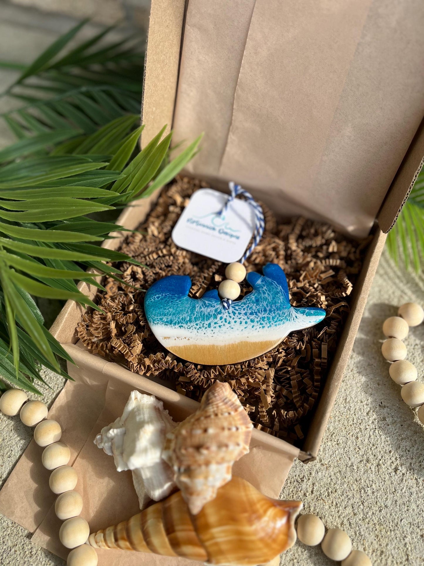 Sea Otter Ornament laying in an ecofriendly gift box