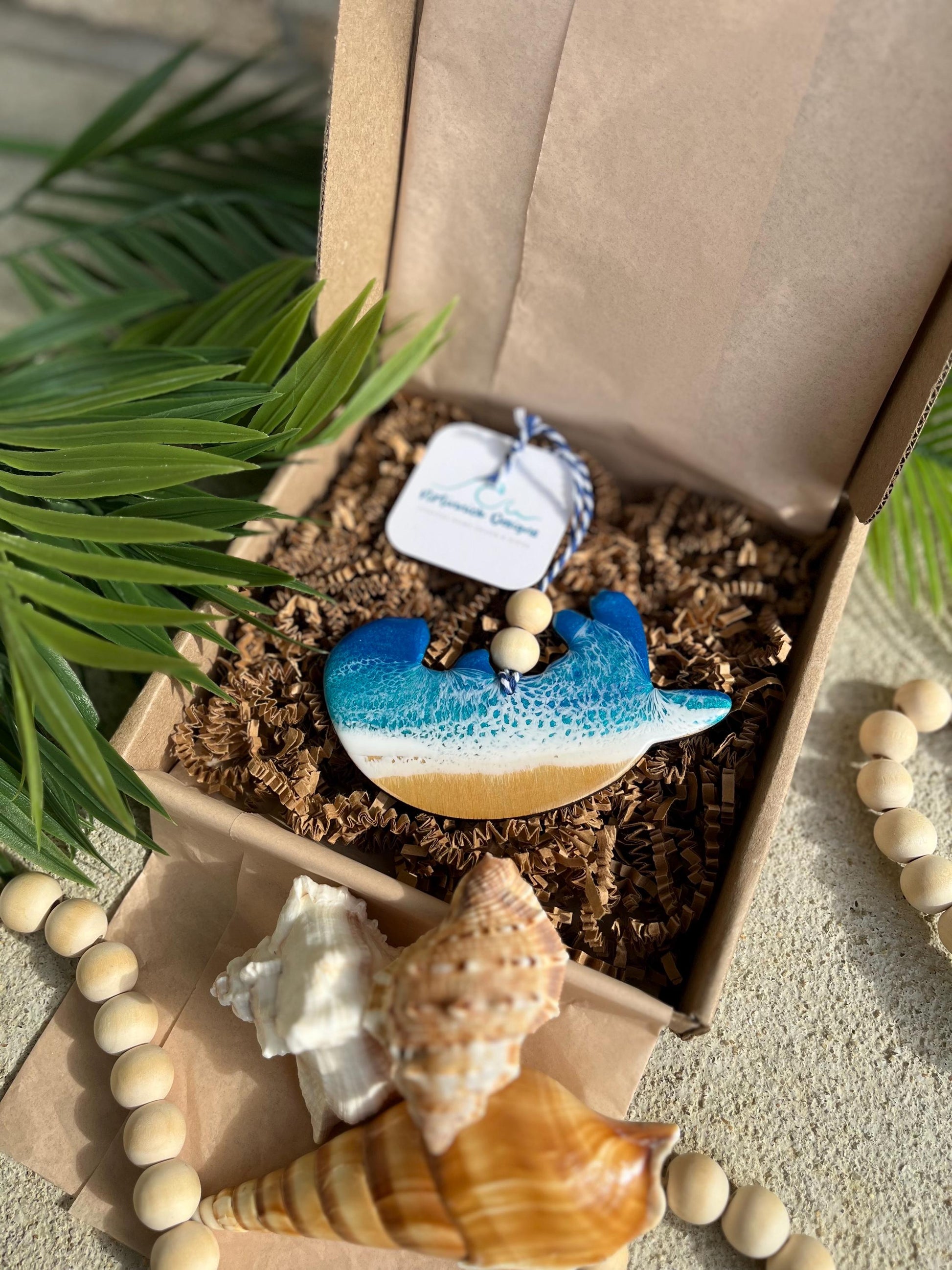 Sea Otter Ornament laying in an ecofriendly gift box